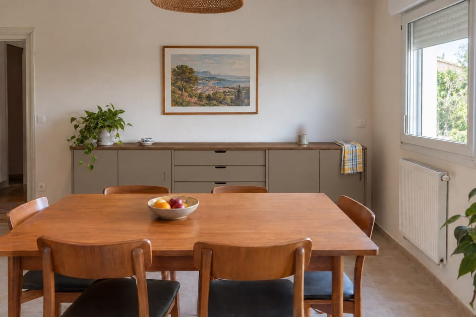 Salle à manger, long buffet bas aux portes et tiroirs taupe, dessus en chêne, table et chaises au premier plan. Portes et tiroirs Bird Nest NH29, dessus Original Oak AA14. Image d'ambiance aux teintes du catalogue.
